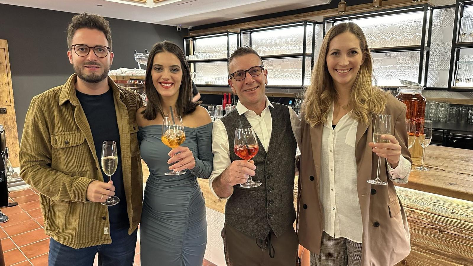 Vier Gäste stoßen mit Sekt und Aperitivo vor der neuen Bar an
