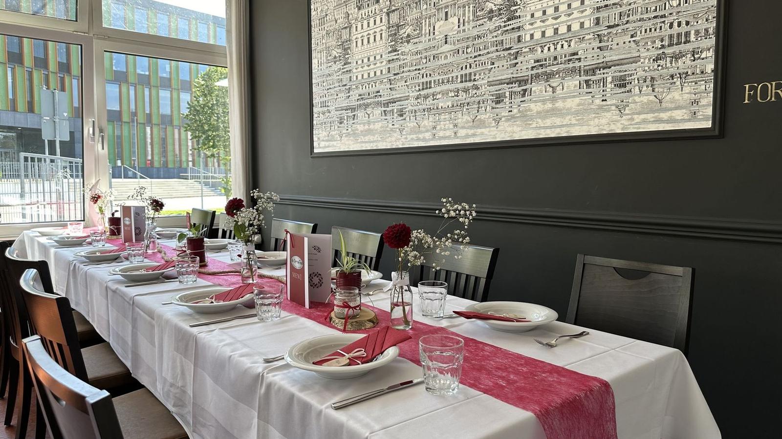 Festtafel mit rotem Tischläufer, Blumen und Menükarten