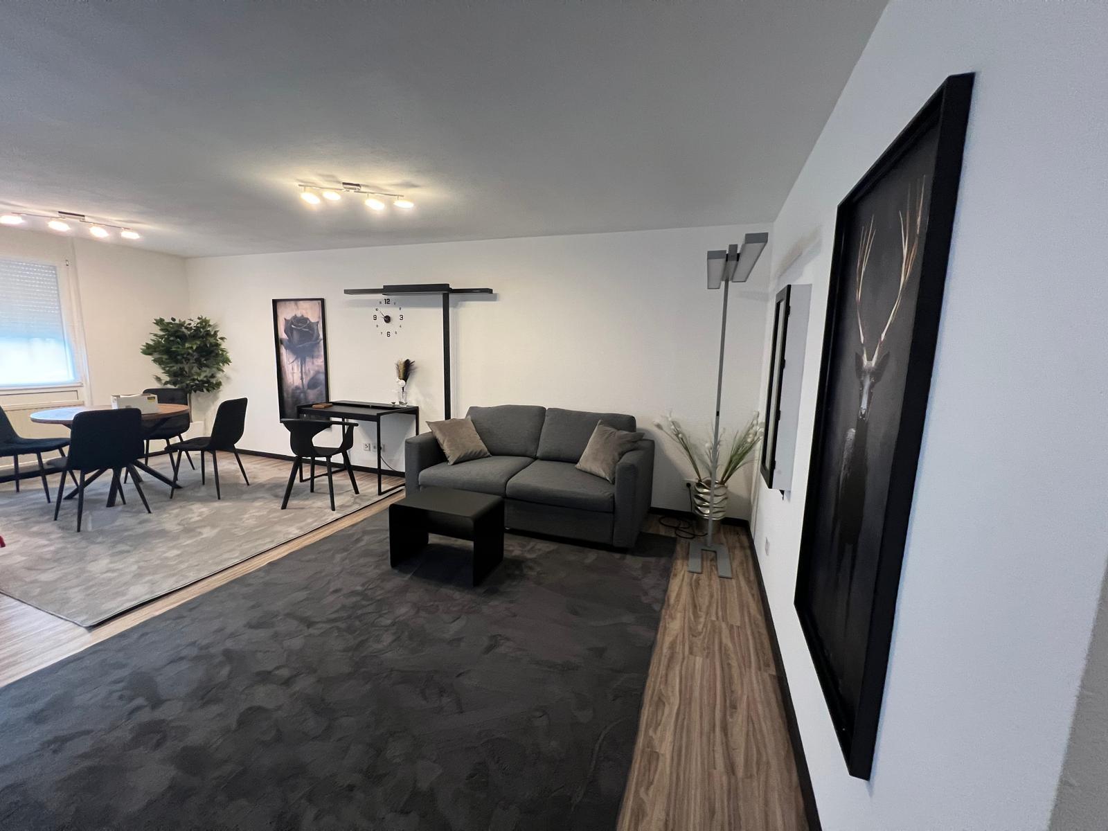 Wohnbereich mit Sofa, Schreibtisch und Esstisch